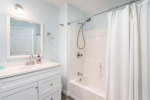 uma casa de banho branca com um lavatório e um chuveiro em Pacific Lights em Lincoln City
