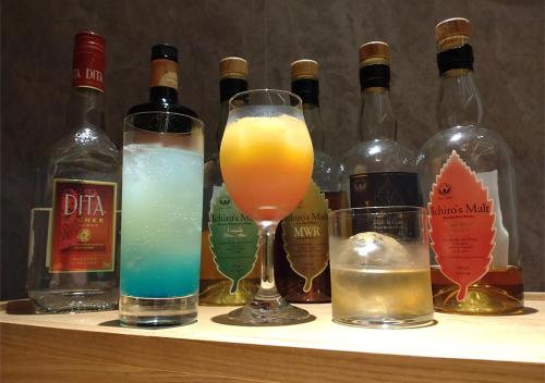 a shelf with several bottles of alcohol and glasses at Hotel and Spa Gift TAKAYAMA in Takayama