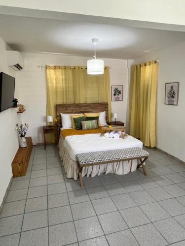 sypialnia z dużym łóżkiem i żółtymi zasłonami w obiekcie Villa Alborada w mieście Arecibo