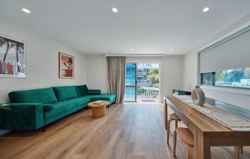 uma sala de estar com um sofá verde e uma mesa em Red Star Palm Beach em Gold Coast