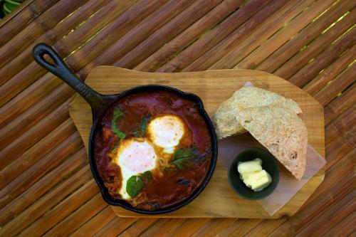 曼巴豪库尔马生态海滩度假村的一个木托盘，上面放着一锅食物和一盘薯条。