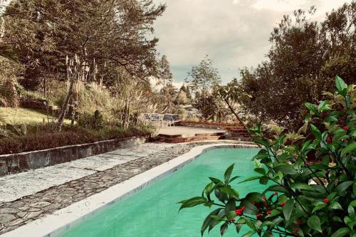 a swimming pool with turquoise water in a yard at Cozy and isolated with hot springs in Quito