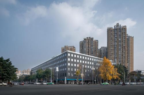a large building in a city with tall buildings at Chengdu Chengshe Hotel - Wenjiang University Town Southwest Caida Branch in Chengdu