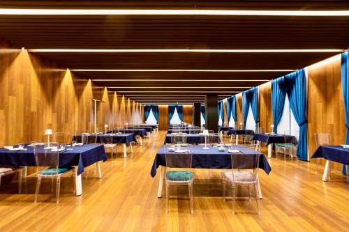 a banquet hall with blue tables and chairs and blue curtains at Chengdu Chengshe Hotel - Wenjiang University Town Southwest Caida Branch in Chengdu