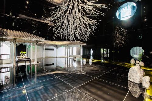 a room with a pavilion with a tree hanging from the ceiling at Chengdu Chengshe Hotel - Wenjiang University Town Southwest Caida Branch in Chengdu