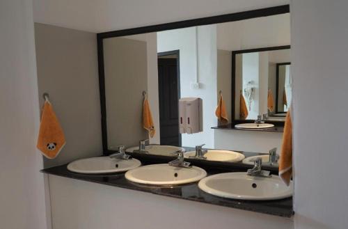 a row of sinks in a bathroom with mirrors at Downtown Vang Vieng Hotel in Vang Vieng