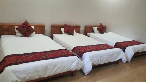 um grupo de quatro camas num quarto em Linh Hằng hotel em Ha Giang