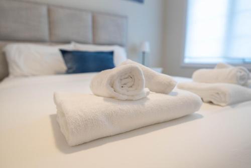 a pile of towels sitting on top of a bed at BRAND NEW home minutes from Niagara Falls. in Thorold