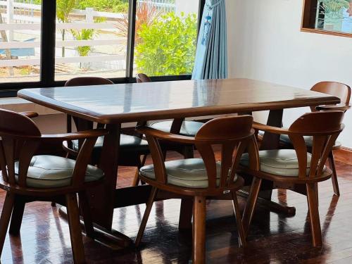 a wooden table with four chairs around it at MD Pool Villa Chumphon in Ban Tha Samet (1)