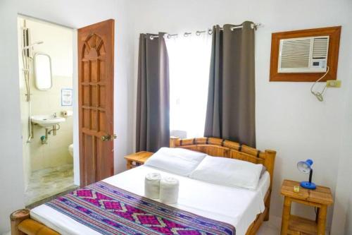 a small bedroom with a bed and a bathroom at Baki Divers and Beach Resort in Dauin