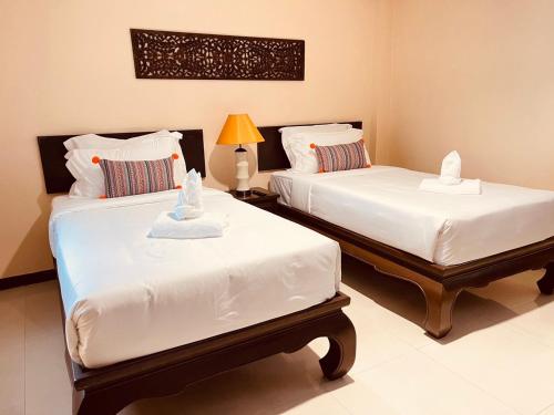 a bedroom with two beds with towels on them at Na Thapae Chiangmai Hotel in Chiang Mai