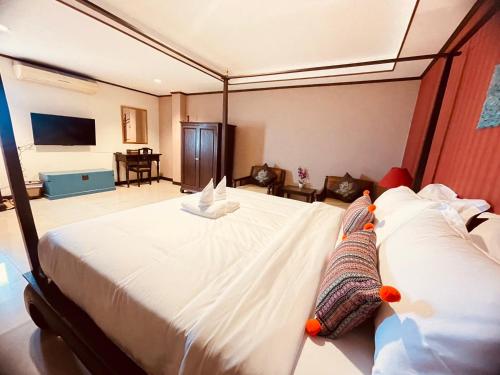 a bedroom with a large white bed in a room at Na Thapae Chiangmai Hotel in Chiang Mai