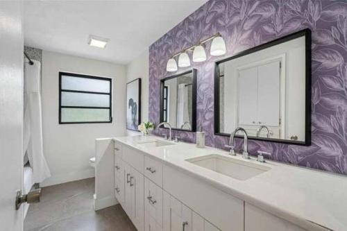 Baño con 2 lavabos y pared púrpura en Tampa/T.T. Pool Home near Bush Gardens & Hard Rock, en Tampa