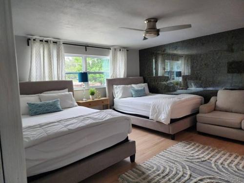 1 dormitorio con 2 camas, silla y sofá en Tampa/T.T. Pool Home near Bush Gardens & Hard Rock, en Tampa