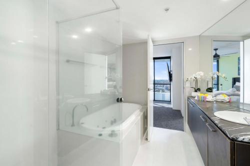 Baño blanco con bañera y lavamanos en River View Oasis in Surfers Paradise - Converted 2 Bedroom Apartment at Avalon - Wow Stay, en Gold Coast