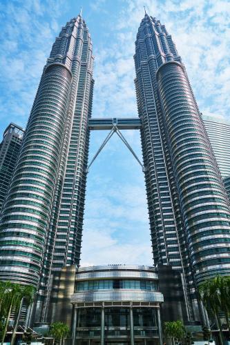 two large skyscrapers in a city with palm trees at Kisetsu no ie, KLCC Kuala Lumpur in Kuala Lumpur