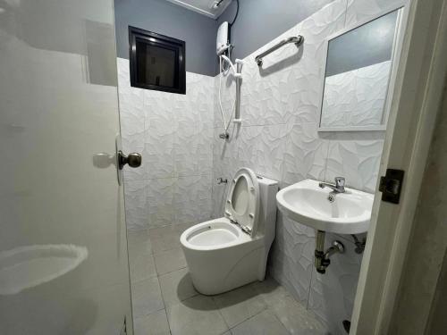 Baño blanco con aseo y lavamanos en P3K Suites Budget Hotel en Manila