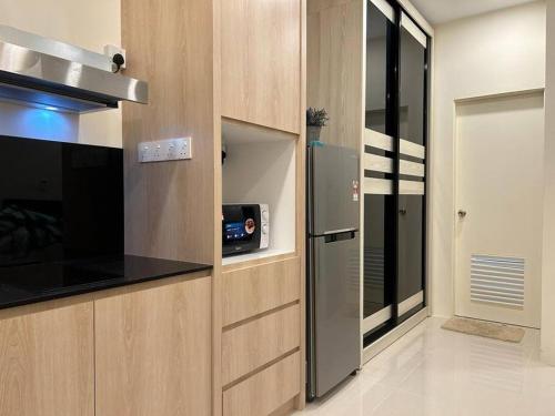 a kitchen with a stove and a refrigerator at Cozy*Home@Riverine Diamond 2 in Kuching
