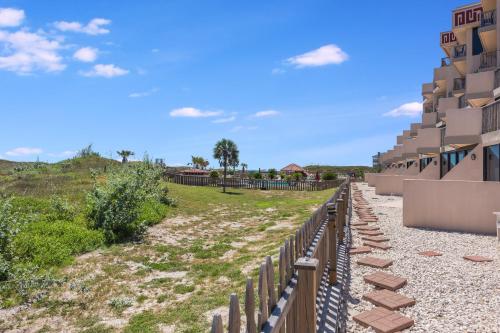 a view of the side of a building with a fence at Mayan Princess 101 Beachfront Resort in Port Aransas