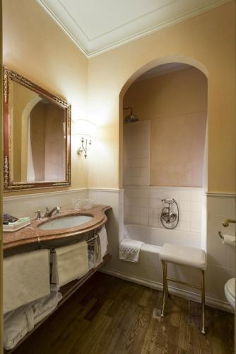 a bathroom with a sink and a tub and a mirror at Posta Donini 1579 - UNA Esperienze in San Martino in Campo
