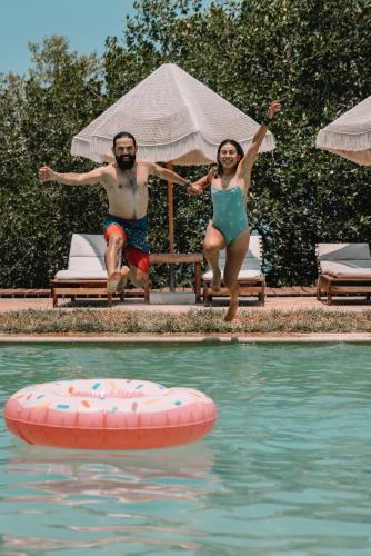 a man and a woman jumping into a swimming pool at Hotel Rio Lagartos in Río Lagartos