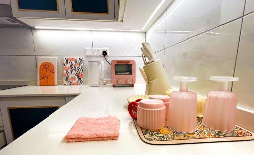 un comptoir de cuisine avec des bouteilles roses sur un comptoir dans l'établissement The Ress - The Axon Bukit Bintang Residence, à Kuala Lumpur