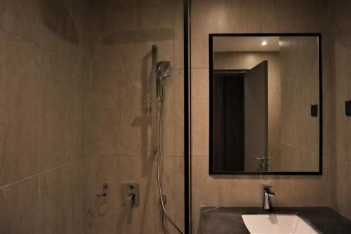 a bathroom with a shower with a sink and a mirror at KSL ESPLANADE HOTEL with HOT SPRING in Klang