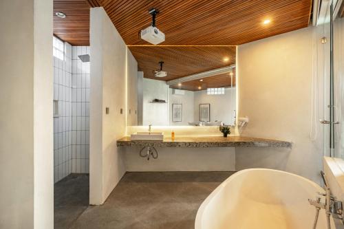 ein Badezimmer mit einer Badewanne und einem großen Spiegel in der Unterkunft Villa Olea in Uluwatu