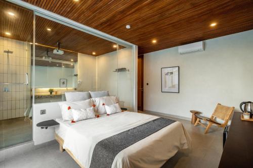 a bedroom with a large bed and a shower at Villa Olea in Uluwatu