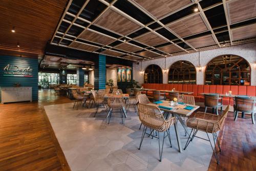 a restaurant with tables and chairs in a room at Ramayana Suites and Resort in Kuta