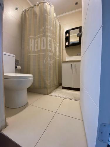 a bathroom with a toilet and a shower curtain at Hospedaje Regina in Santiago