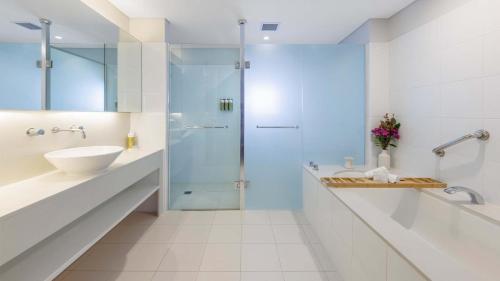 a bathroom with a glass shower and a sink at Elysia Wellness Retreat in Pokolbin
