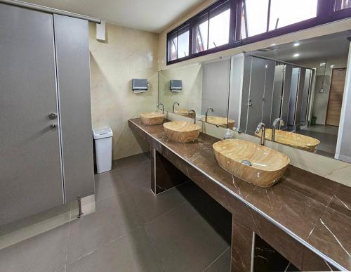 uma casa de banho com quatro lavatórios e uma fila de espelhos em Malee Hotel em Chiang Mai