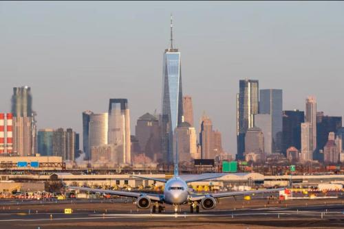 an airplane on an airport runway with a city at Brick City Bliss (30 mins to NYC) in Newark