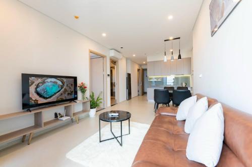 a living room with a couch and a tv at CONDOTEL 5 SAO THE SÓNG VŨNG TÀU Mr VƯƠNG VIP in Vung Tau