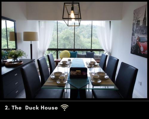 a dining room table with chairs and a large window at ThatNicePlace in Selesa Hillhome, Bukit Tinggi, Bentong, Genting in Bentong