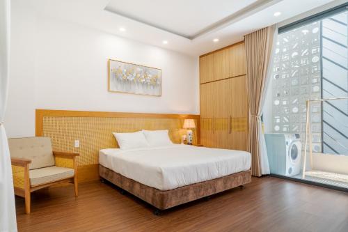 ダナンにあるMay Home Apartment Da Nangのベッドルーム1室(ベッド1台、椅子、窓付)