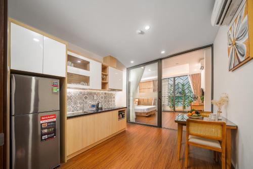 a kitchen with a stainless steel refrigerator and a table at May Home Apartment Da Nang in Danang