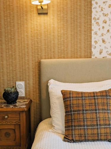 a bedroom with a bed and a nightstand with a pillow at LE CEMAROSE Cottage & Spa Terrace Garden & lovely View in Épernay
