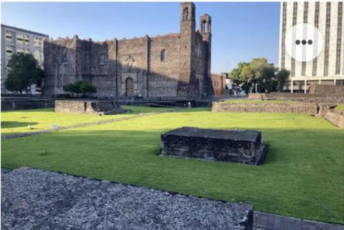 ein altes Schloss auf einem Grasfeld mit Gebäuden in der Unterkunft Habitación económica y pequeña con baño privado cerca del Centro Histórico in Mexiko-Stadt