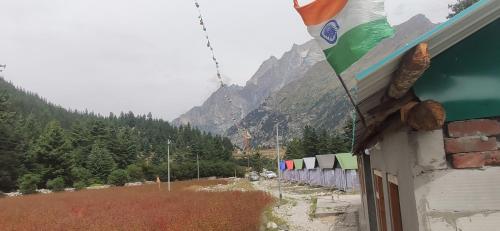 a flag on the side of a building with a mountain at Sangla Valley Camping in Saturang