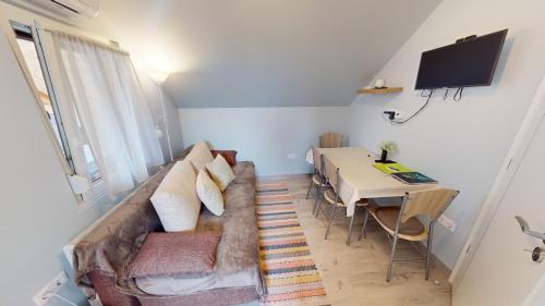 a living room with a couch and a table at Silver Zsóry Apartman in Mezőkövesd