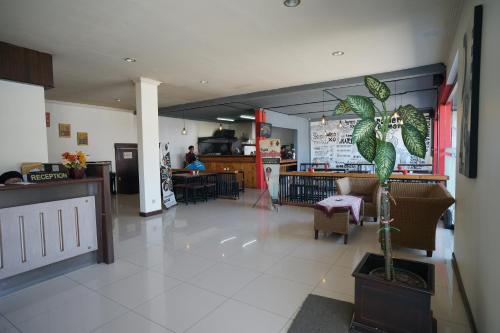 um restaurante com uma planta no meio de uma sala em Hotel Puri Pangalengan em Bandung