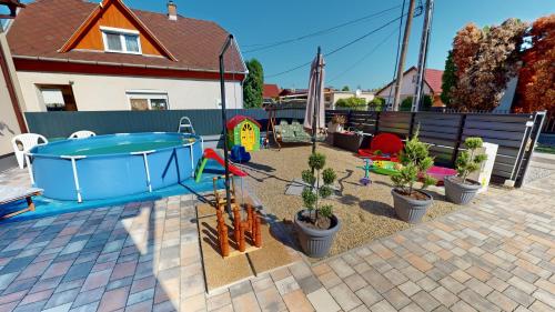 a backyard with a hot tub and potted plants at Silver Zsóry Apartman in Mezőkövesd
