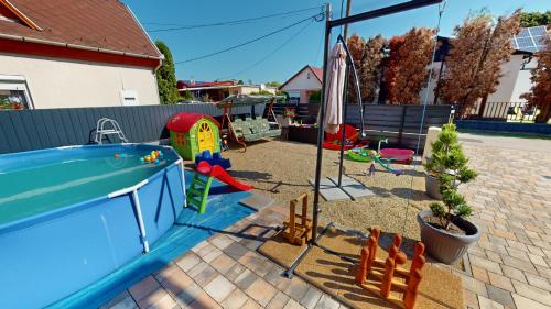 une cour avec une aire de jeux, une piscine et des jouets dans l'établissement Silver Zsóry Apartman, à Mezőkövesd