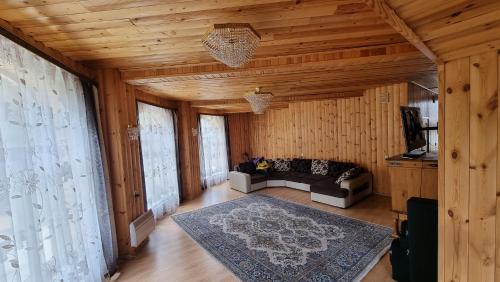 ein Wohnzimmer mit einem Sofa und Holzwänden in der Unterkunft Osobnyak in Schtschutschinsk