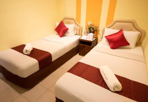 two beds in a hotel room with red and white pillows at Sun Inns Hotel Lagoon near Sunway Lagoon Theme Park in Petaling Jaya
