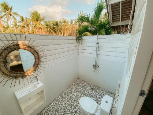 a bathroom with a mirror and a toilet at Love Coconut Bungalow in Gili Trawangan