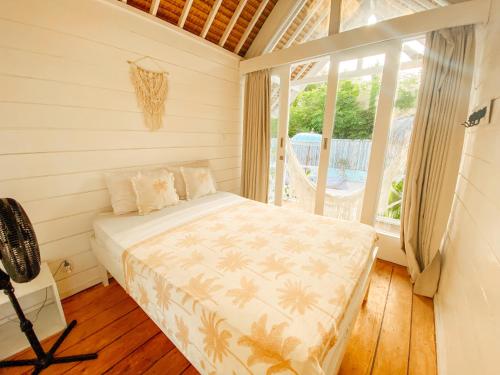 a bedroom with a bed in a room with a window at Love Coconut Bungalow in Gili Trawangan