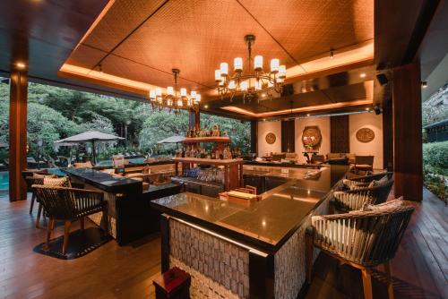a restaurant with a bar with chairs and tables at Ramayana Suites and Resort in Kuta